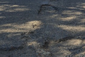 Očajan asfalt u krugu bolnice, prepun kratera