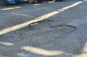 Očajan asfalt u krugu bolnice, prepun kratera