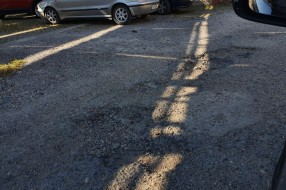 Očajan asfalt u krugu bolnice, prepun kratera