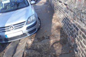 Loš trotoar i automobili preko pešačke staze u Ulici Park Ferenca Rajhla
