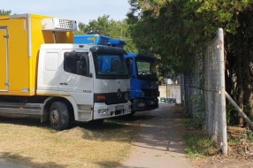 Kamioni na zelenoj površini i pešačkoj stazi u Aleksandrovu