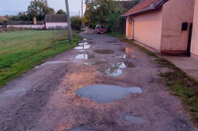 Neasfaltirana ulica, velike rupe i bare (Ulica Anđe Ranković)