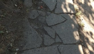 Razbijeni beton trotoara iza samoposluge u Malom Bajmoku