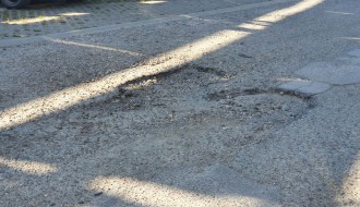 Očajan asfalt u krugu bolnice, prepun kratera