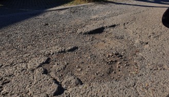 Očajan asfalt u krugu bolnice, prepun kratera