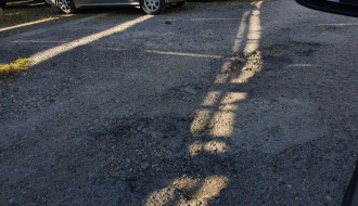 Očajan asfalt u krugu bolnice, prepun kratera