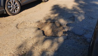 Očajan asfalt u krugu bolnice, prepun kratera