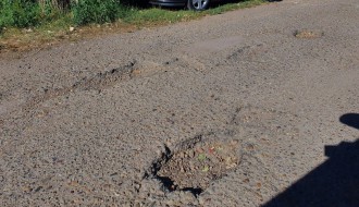 Očajan asfalt u krugu bolnice, prepun kratera