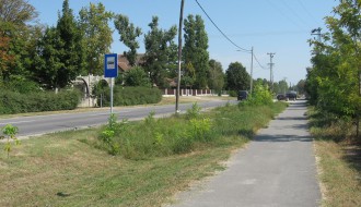 Zarasla biciklistička staza i visoka trava pored samog međunarodnog puta