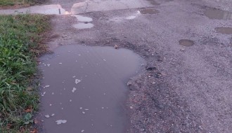 Neasfaltirana ulica, velike rupe i bare (Ulica Anđe Ranković)