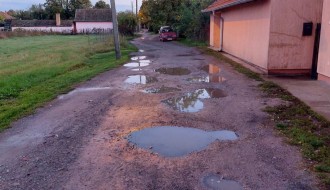 Neasfaltirana ulica, velike rupe i bare (Ulica Anđe Ranković)